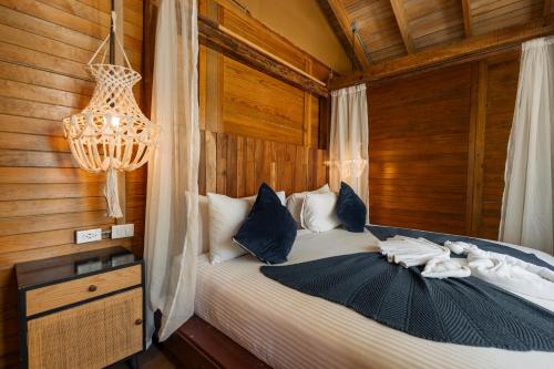 - une chambre avec un lit et un lustre dans l'établissement Nílu Isla Mujeres by Selina, à Isla Mujeres