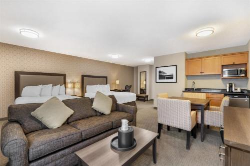 a hotel room with a couch and a bed and a kitchen at Best Western Plus Country Meadows Inn in Aldergrove