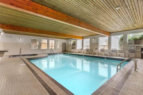 a large swimming pool with chairs in a building at Best Western Plus Country Meadows Inn in Aldergrove