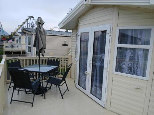 a patio with a table and chairs on a deck at Seascape - caravan next to Fantasy Island Ingoldmells, 2 dogs max - East Coast Holidays in Ingoldmells