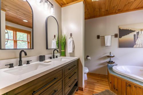 Un baño con dos lavabos, una bañera y un inodoro. en Country Life, en Vilas