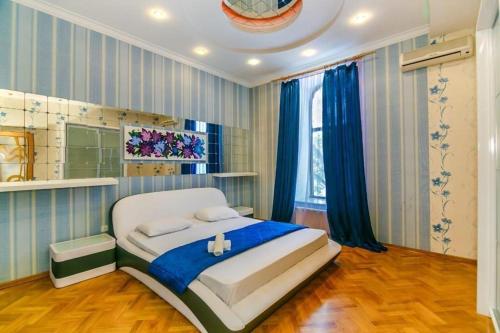 a bedroom with a large bed in a room with blue curtains at Caspian in Baku