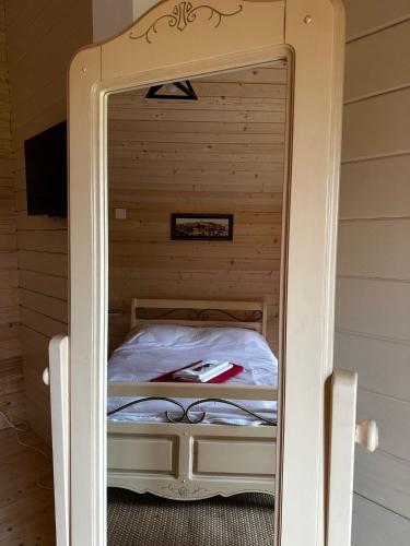 a mirror in a small room with a bed at Casa cu cerdac in Şarul Dornei