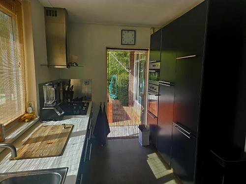 a kitchen with a door leading to a yard at Villa in the forest of Amsterdam with Pool in Velsen-Zuid