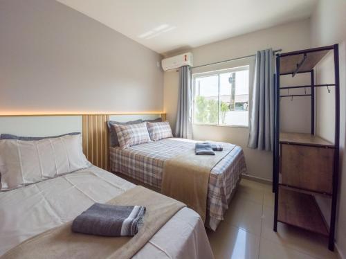 een kleine slaapkamer met twee bedden en een raam bij Curta Praia de Armação - Casa Violeta in Penha