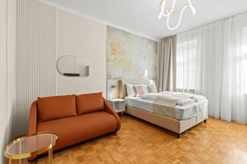 a bedroom with a bed and a couch and a table at Meidling Rooms I 1 Min to U6 I Self Check In in Vienna