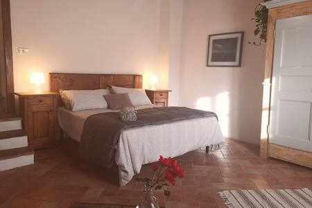 1 dormitorio con 1 cama, 2 mesas y una ventana en Fantastic Apartment in the Heart of Toscana, en Castiglion Fiorentino