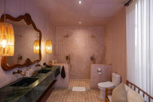 a bathroom with a sink and a toilet and a mirror at Villa Pinkaboo - Gorgeous and Luxury One-Bedroom Villa in the Heart of Canggu in Canggu