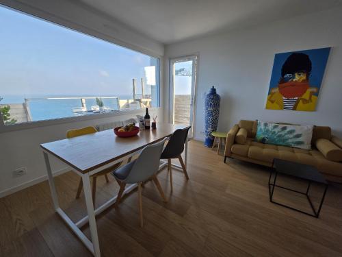 a living room with a table and a couch at Joli cocon vue mer exceptionnelle proche plages in Plouguerneau