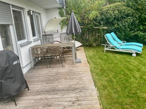a patio with a table and chairs and an umbrella at 2 Zimmer Ferienwohnung mit Terrasse fußläufig zu S-Bahn nach München und See in Wörthsee