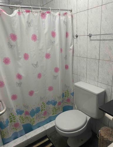 a bathroom with a toilet and a shower curtain at Sítio Serra Verde in Guapimirim