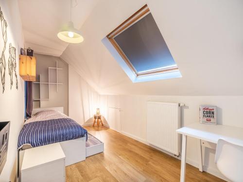 a attic bedroom with a bed and a skylight at Au Coin in Galopen