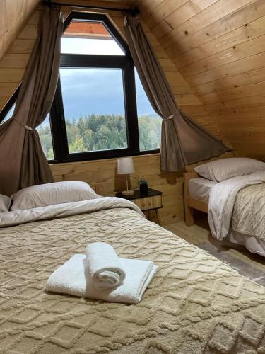 a bedroom with two beds in a log cabin at Brvnara Šapat Borova Tara in Sekulić 