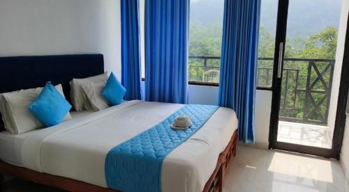 1 dormitorio con 1 cama con cortinas azules y balcón en Rock Starzz Resort Munnar, en Suryanelli