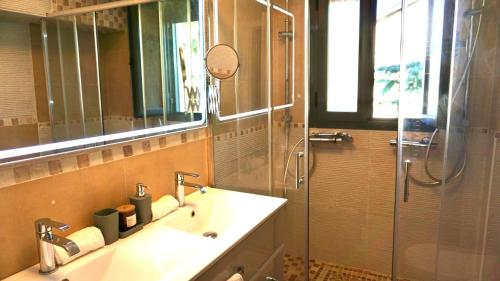 a bathroom with a sink and a shower with a mirror at Villa Los Ángeles - El Espinar in Los Ángeles de San Rafael