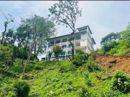 un edificio en la ladera de una colina en Rock Starzz Resort Munnar, en Suryanelli