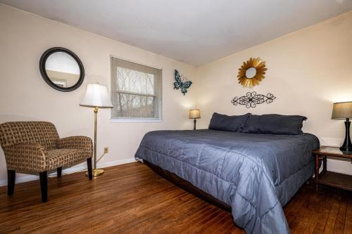 a bedroom with a bed and a chair and a mirror at Three Bedroom Cabin in Nashville