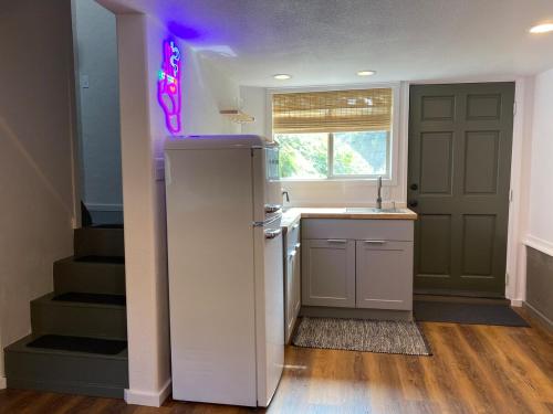 a kitchen with a sink and a refrigerator with a purple light at Unique Farm Apartment with Woodstove in Eureka