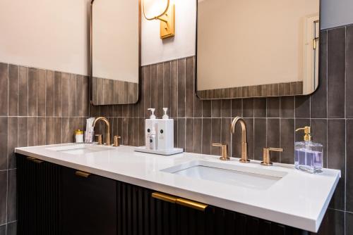 a bathroom with two sinks and two mirrors at Hollyhock Suite 512 in Louisville