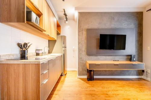 Una cocina con un fregadero y un televisor en la pared. en ParkSide Jardim Paulista, en São Paulo