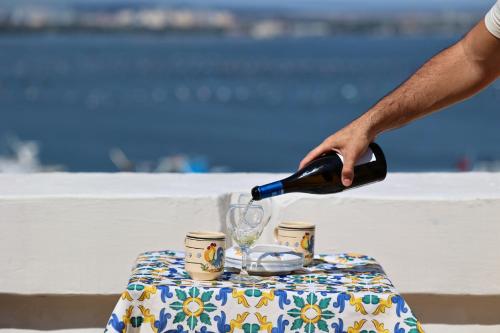 a person pouring wine into a glass on a table at Il Palazzino in Taranto
