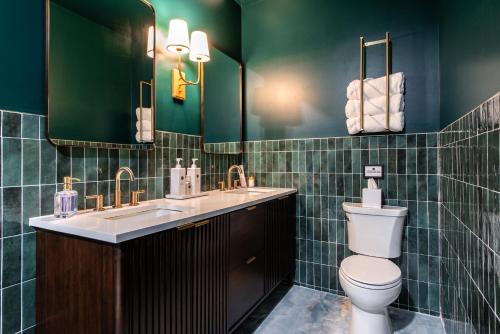 een groene badkamer met een toilet en een wastafel bij Hollyhock Suite 511 in Louisville