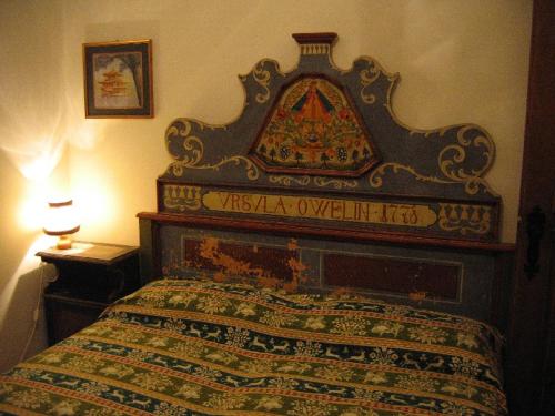 a bed with an ornate headboard in a bedroom at Appartamento in chalet ampezzano in Alvera