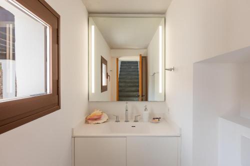 a white bathroom with a sink and a mirror at New! Villa Can Xic in Santa Eularia des Riu