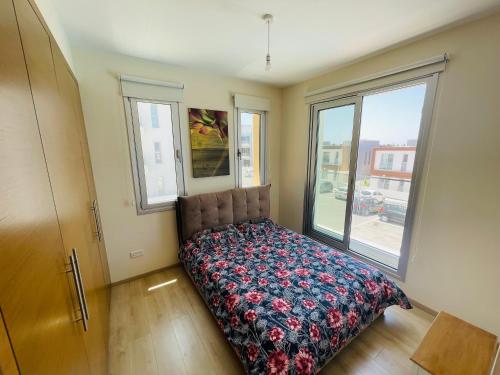a bedroom with a bed and a large window at Rose Gardens Cozy Villa in Paphos City