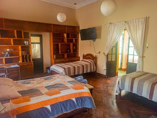 a room with two beds and a television in it at Colors House in Sucre