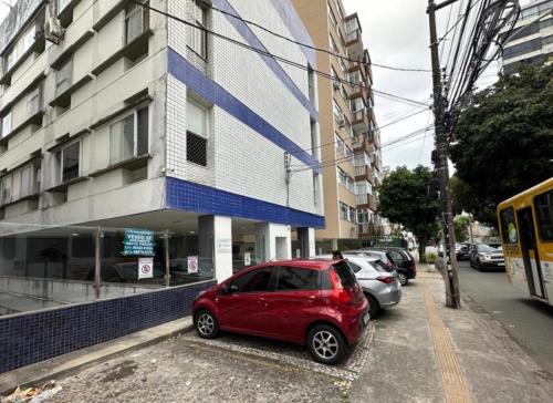 a red car parked in front of a building at Apartamento na graça, 03 suítes, Sua melhor opção em Salvador in Salvador