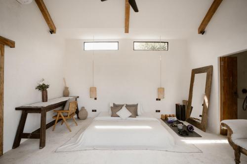 a bedroom with a bed and a table and a mirror at Villa Bella - Stylish 3-Bedroom Oasis with Mediterranean Charm in Canggu