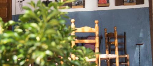 two wooden chairs sitting next to a wall at casa rural la Venta de Agar Orgaz, Toledo 30 min Puy du fou in Orgaz