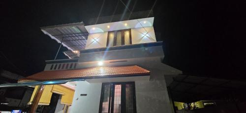 a tall white building at night with at Ashabhavan in Varkala