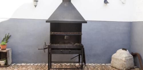 a black stove in a room with a wall at casa rural la Venta de Agar Orgaz, Toledo 30 min Puy du fou in Orgaz
