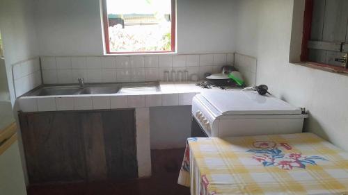 une petite cuisine avec un évier et une fenêtre dans l'établissement Petite Maison Sainte-Marie, Madagascar, sur l'île Sainte-Marie