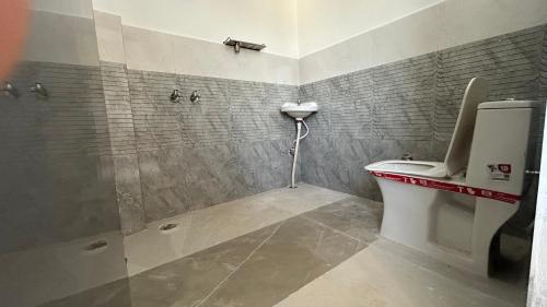 a bathroom with a shower and a toilet and a sink at Air Rooms in Lohārakot