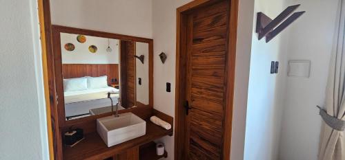 a bathroom with a mirror and a sink and a bed at Upwind Villas Boutique - Praia de Maceió - Camocim - CE in Maceio