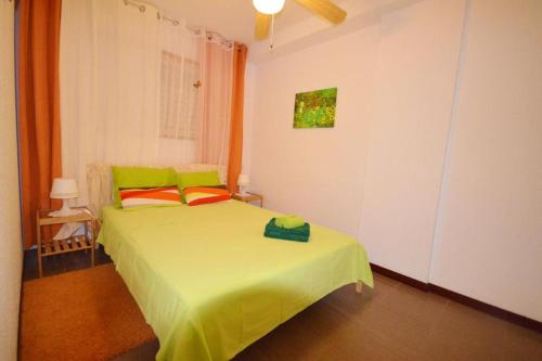 1 dormitorio con 1 cama con sábanas verdes y almohadas de color naranja en Parque Royal 1 Apartamento Costa Adeje, en Adeje