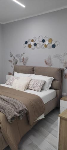 a bed in a bedroom with a wall with flowers at Casa vacanza Luna in Eboli