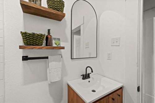 un bagno bianco con lavandino e specchio di Hardy House Vintage Bungalow, Huge Yard! a Houston