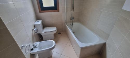 a bathroom with a toilet and a sink and a bath tub at Piso con piscina entre 2 playas - Floor with pool between 2 beaches in O Porto de Espasante