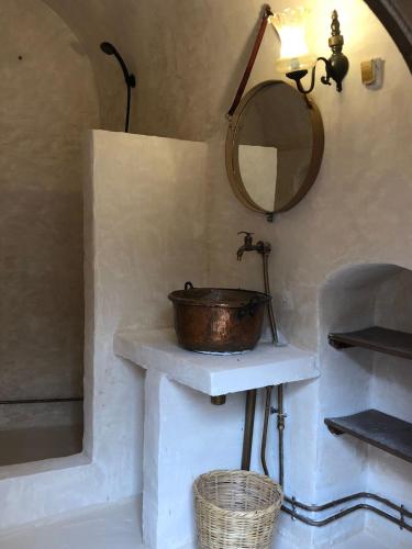 a bathroom with a copper sink and a mirror at échappée troglodyte unique in Tūjān