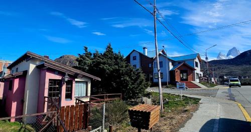 a row of houses on a street with mountains in the background at Casa Pier Giorgio Bella Vista in El Chalten