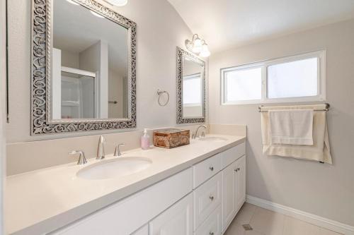 Un baño blanco con lavabo y espejo. en Spacious 4-bedroom house in tranquil Rowland Heights with City View, en Rowland Heights