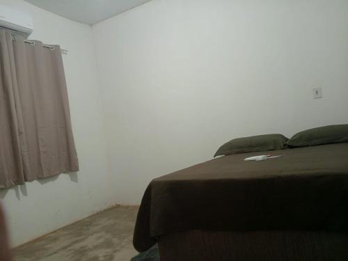 une chambre avec un lit et une fenêtre dans l'établissement Casa de Temporada WK, à Campo Alegre