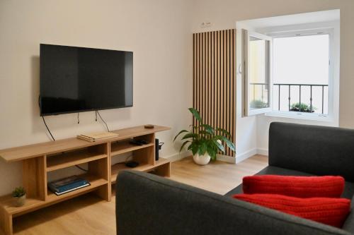 a living room with a flat screen tv and a couch at Casa Lusíadas in Constância