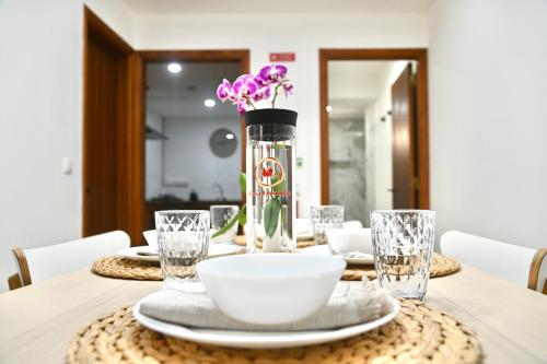 a table with plates and a vase with purple flowers at Casa Lusíadas in Constância
