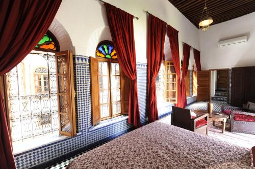 una camera da letto con vetrate colorate e un letto di Riad Au 20 Jasmins a Fes