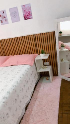 a bedroom with a bed with a wooden headboard at Quartos Privados em casa Mobiliada in Londrina
